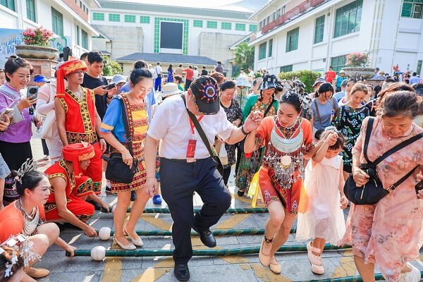 参加2024年海南黎族苗族传统“三月三”保亭主会场活动游客市民欢快地跳起竹竿舞。（文宏武 摄）